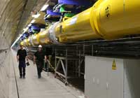 Workers walk past the first section of the European XFEL linear accelerator, which has been nearly completely assembled in the tunnel. Image courtesy of DESY