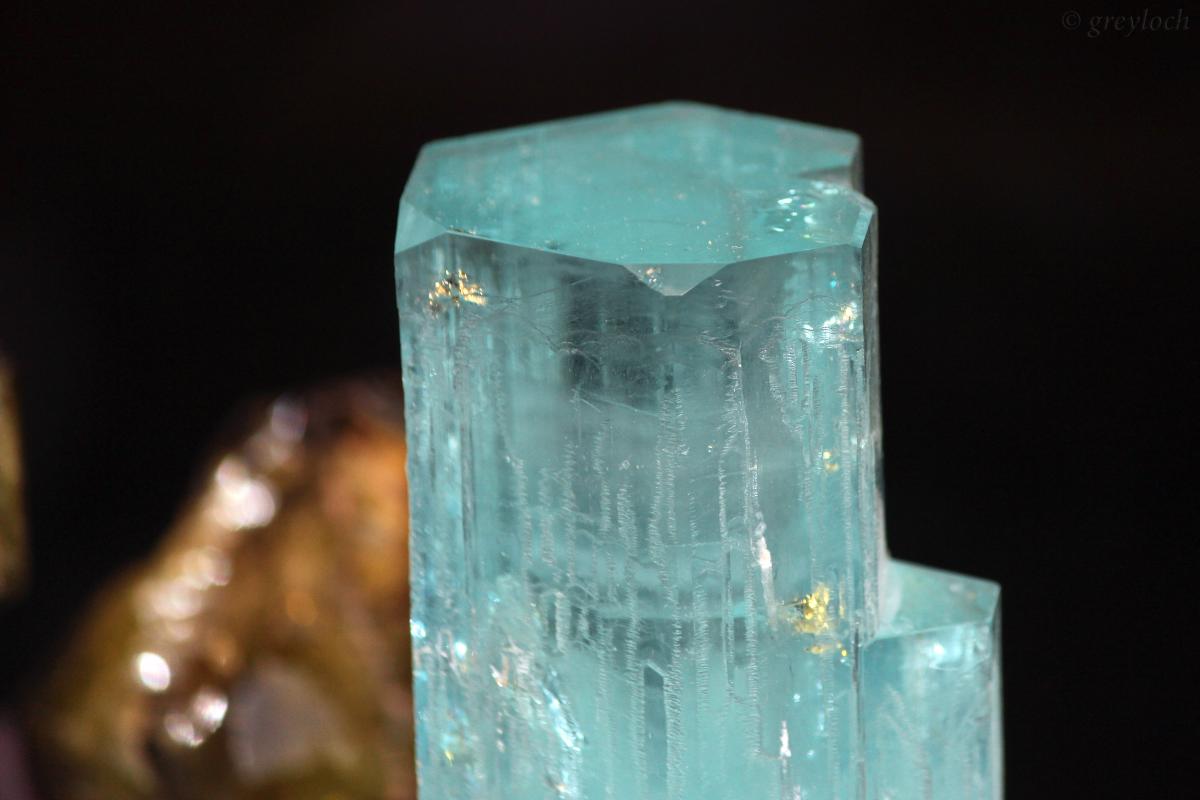 A raw, uncut crystal of aquamarine, a gemstone containing beryllium