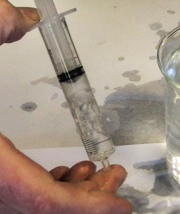 By creating a partial vacuum inside the syringe, students see how water boils when pressure is reduced