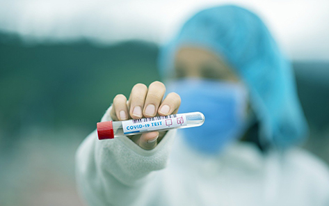 Mujer sosteniendo un tubo de ensayo con resultado negativo de la prueba COVID