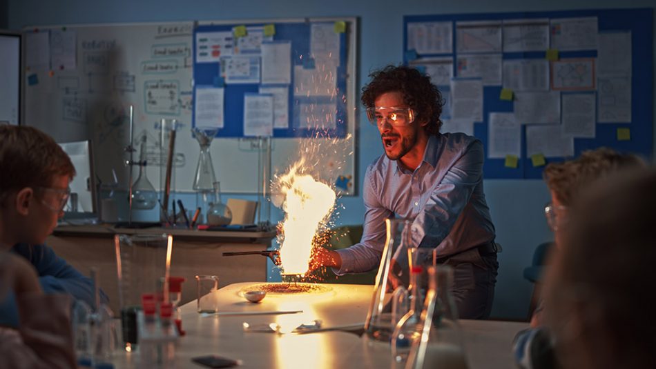 A teacher demonstrates a reaction that produces a large flame.
