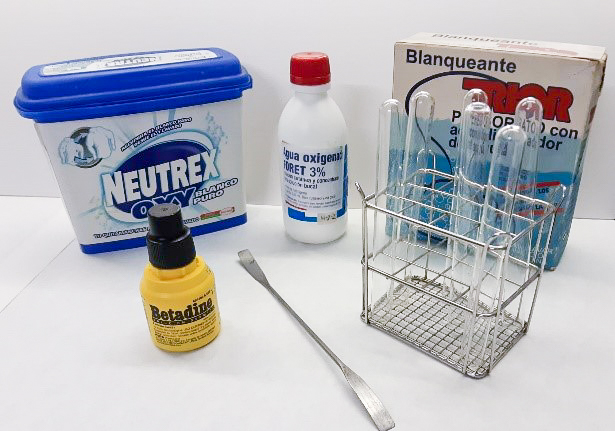 Metal rack with glass test tubes, spatula, plastic bottles, plastic and cardboard boxes of different sizes containing reagents and detergents.
