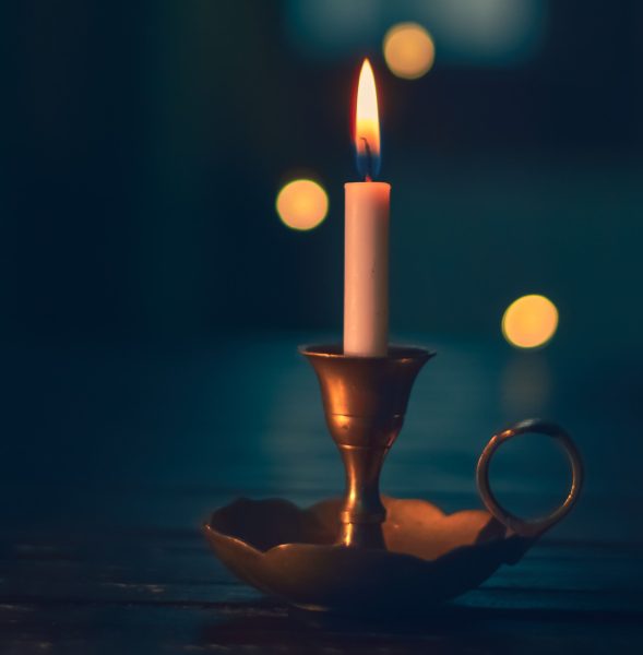 A lit candle sitting on top of a table.