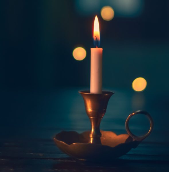 A lit candle sitting on top of a table.