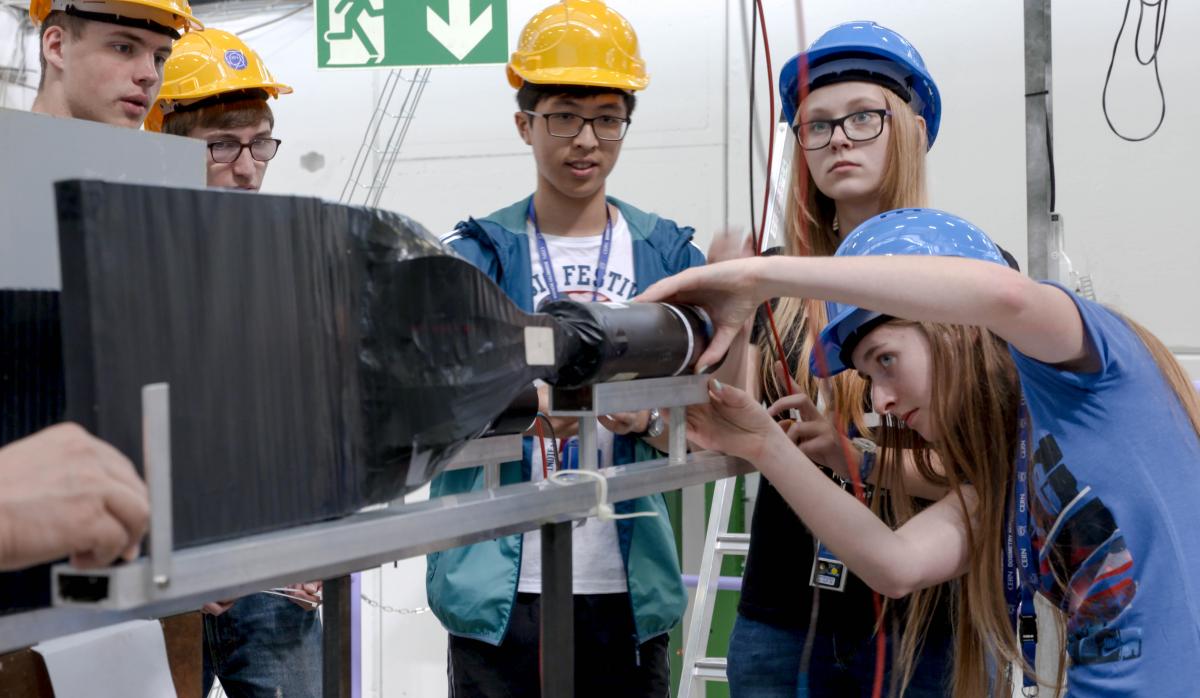 Students from the 2016 winning teams helping each other to set up their experiments in the beamline