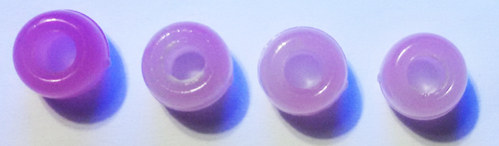 Colour intensities of UV beads exposed to UV light, from left to right: without sunscreen; with SPF 20; SPF 50; SPF 90.