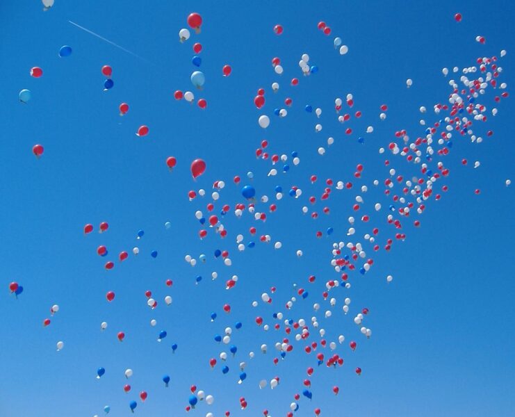 Colourful helium balloons against a blue sky