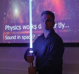 Professor Welsh with a lightsaber during a demonstration.