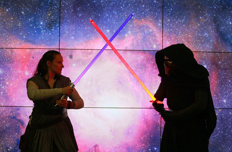 Demonstrators dressed as a Jedi and a Sith fighting with lightsabers.