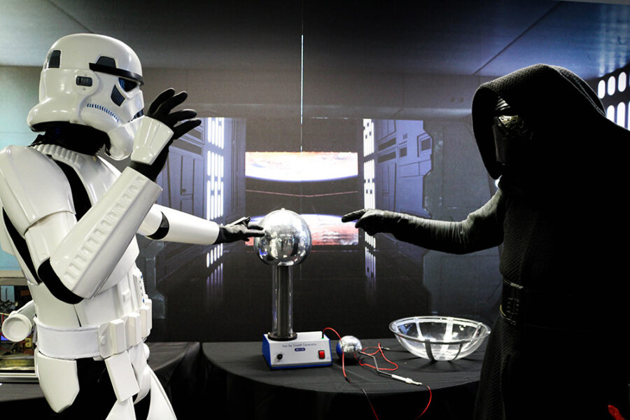 Demonstrators dressed as stormtrooper and a Sith play with a Van der Graaff generator.