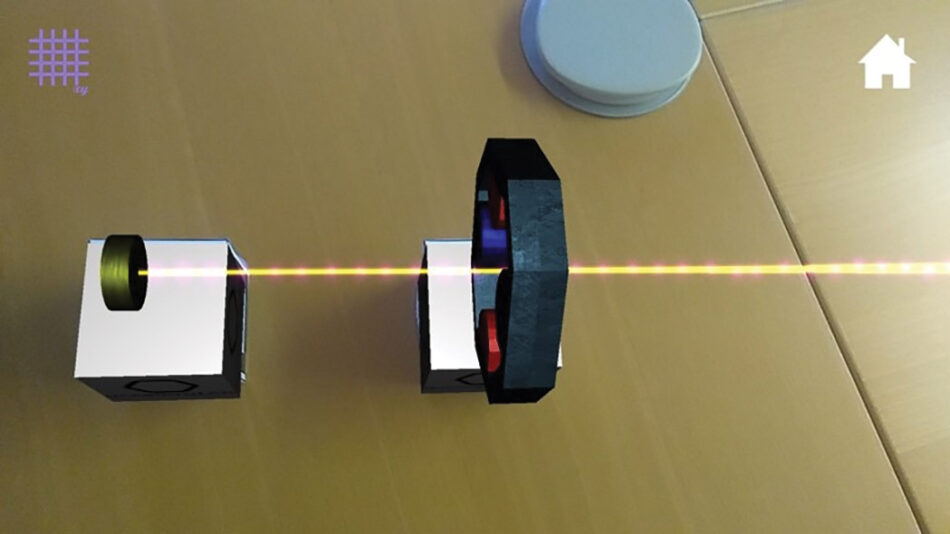 A screenshot of acceleratAR app with the particle source and quadrupole magnet cubes, showing the virtual light beam being focused.