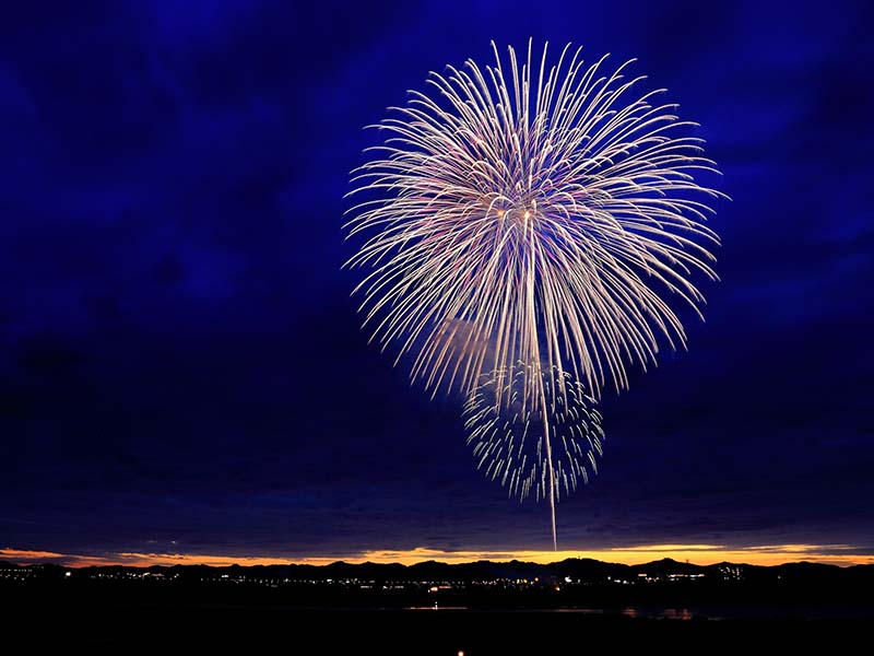 White fireworks against a blue sky.