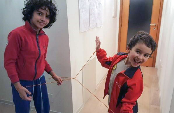 Two children playing with ropes and knots