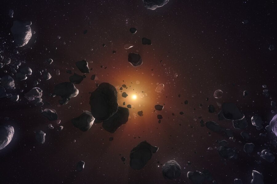 Grey rocks of various sizes appear in the foreground against the diffuse orange glow of a yellow star in the background.